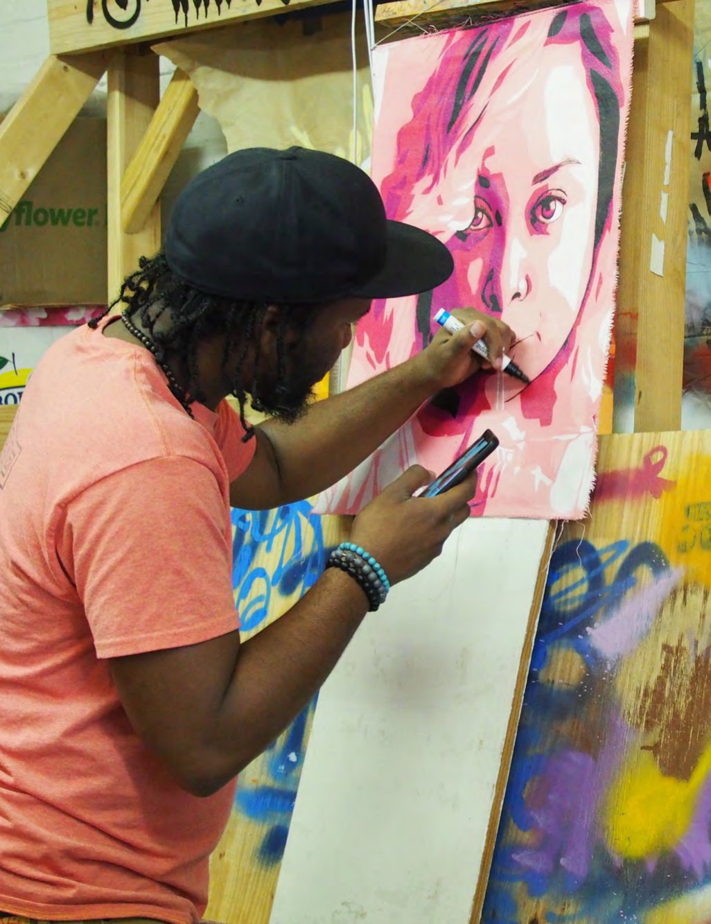 Reggie LeFlore painting a portrait on a large panel