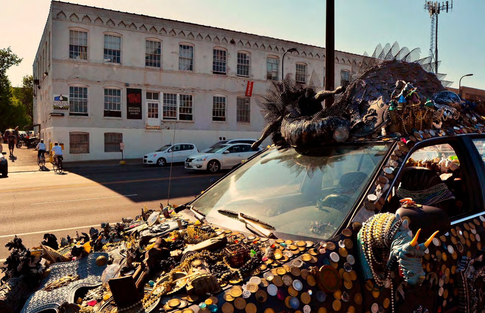 Art car covered in found objects parked across the street from the Thorp Building