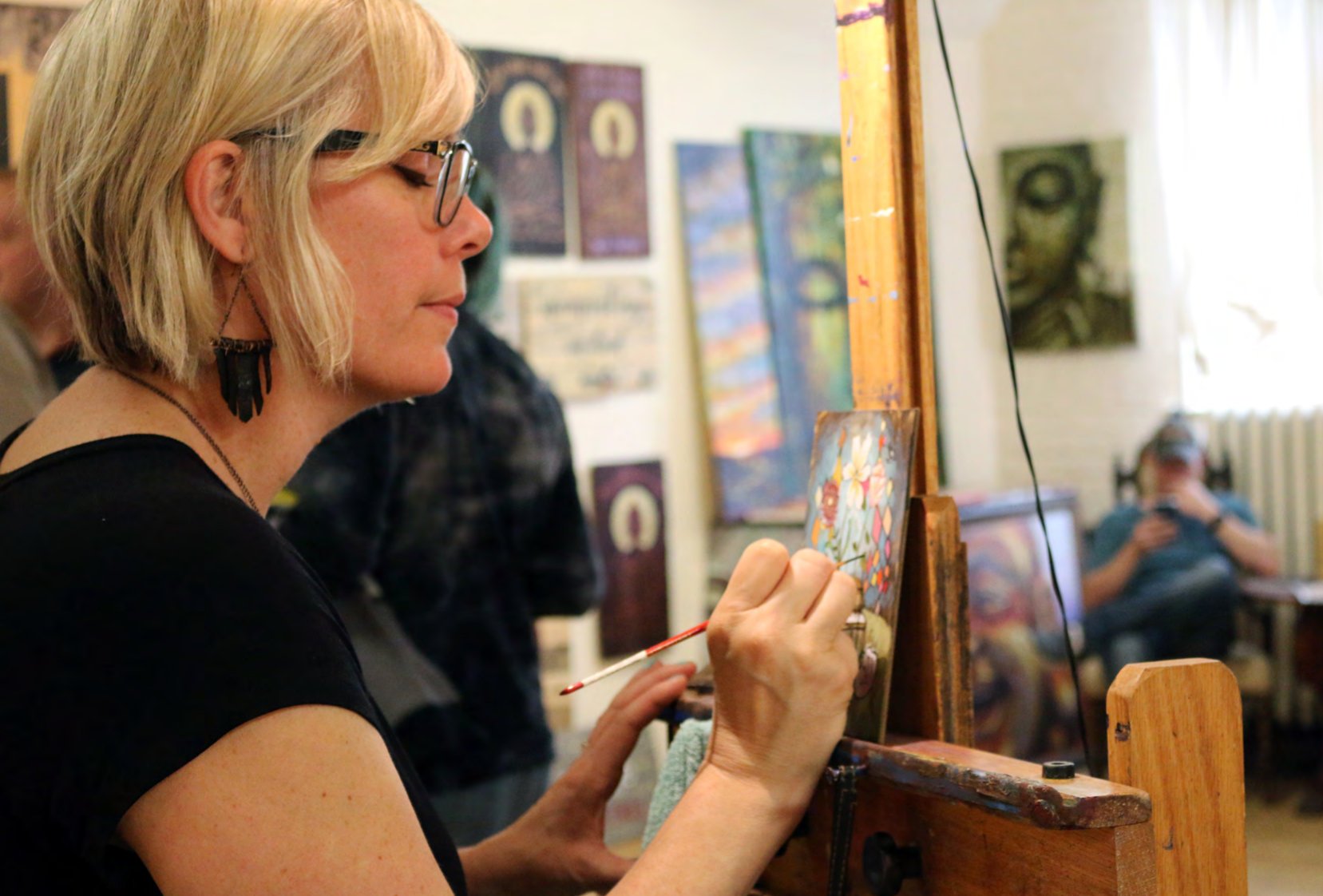 Heather Renaux painting at an easel in her studio