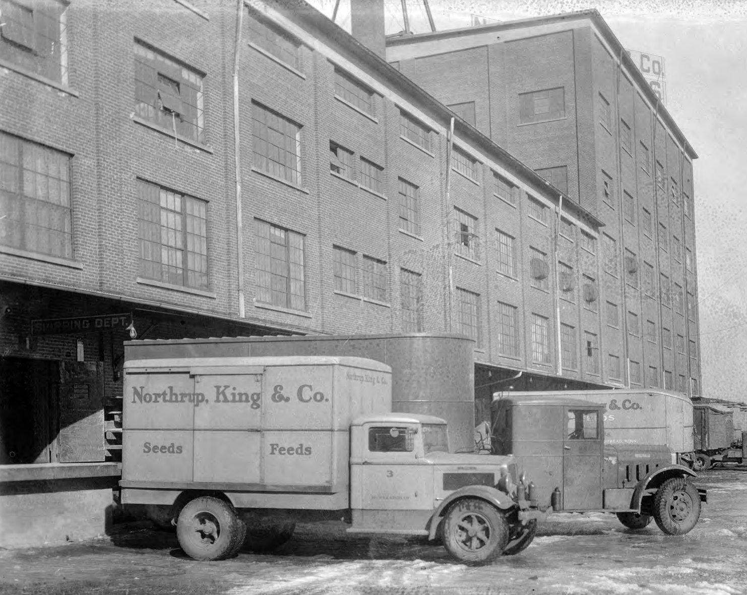 Historic photo of Northrup King & Co. delivery trucks at the company's shipping platform