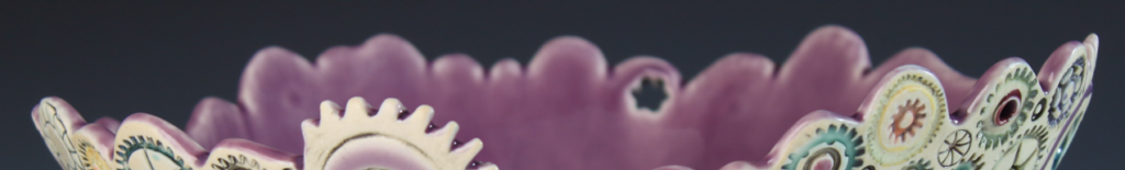 A purple ceramic bowl with a scalloped, gear-like rim featuring circular decorative patterns.
