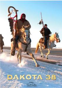 Two riders in winter clothing carry staffs on horseback through snow for the film Dakota 38.