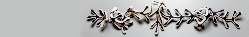 A wall sculpture composed of several branching, coral-like white ceramic pieces with black outlines.